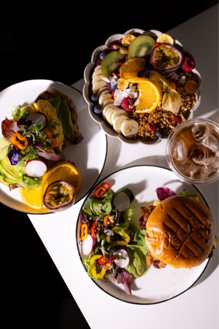 Gedeckter Tisch mit Bowl, Frühstücksburger und Cold Brew